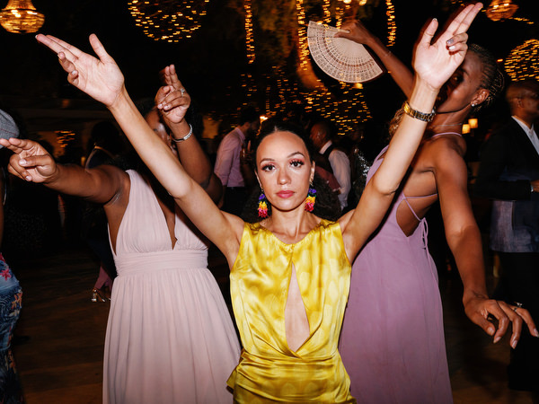 Guests dancing energetically under woven chandeliers at Island Resort The Residence luxury Nigerian wedding in Greece.