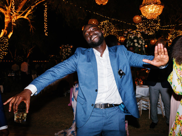 Young wedding guest dancing enthusiastically at Island Resort The Residence Nigerian destination wedding in Athens.