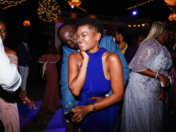 Guests dancing energetically under woven chandeliers at Island Resort The Residence luxury Nigerian wedding in Greece.