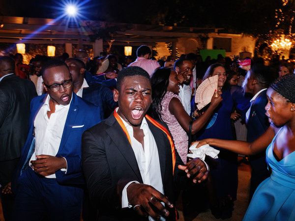 Young wedding guest dancing enthusiastically at Island Resort The Residence Nigerian destination wedding in Athens.