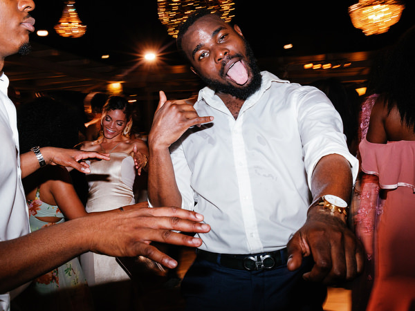 Guests dancing under string lights at Island Resort The Residence Nigerian destination wedding in Athens Greece.