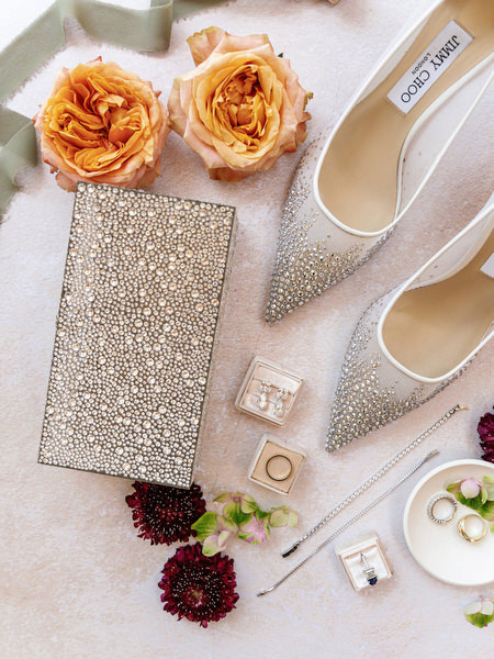 Jimmy Choo heels, glitter clutch, coral roses, and bridal jewelry styled for Athens wedding