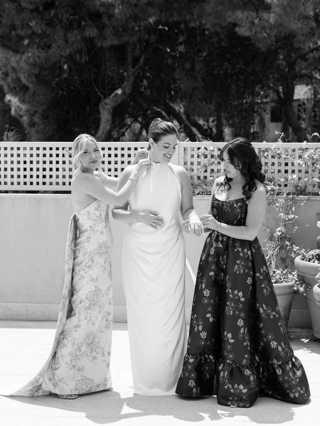 Bridesmaids standing beside bride in formal gowns before Jewish wedding ceremony