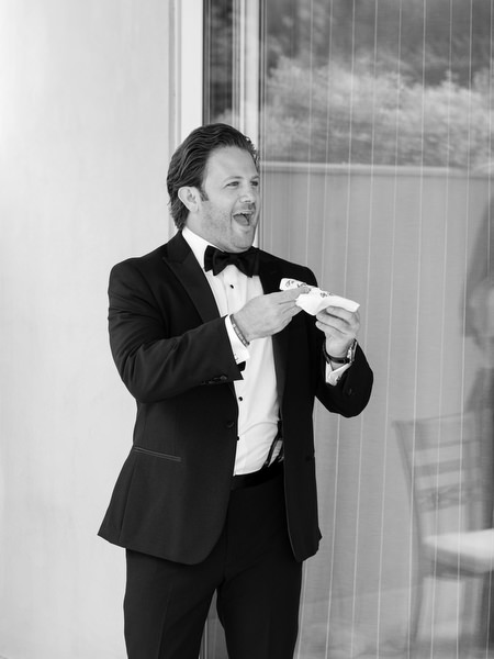 Bride's brother smiling emotionally while holding note before ceremony