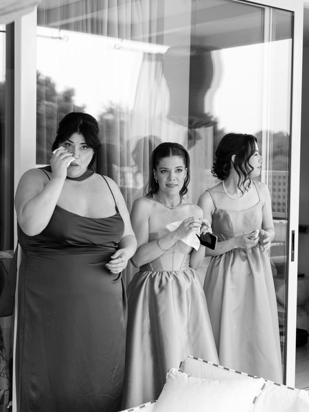 Bridesmaids reacting emotionally while watching pre-ceremony moment indoors