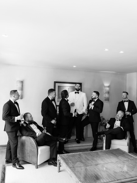 Groom and groomsmen in tuxedos relaxing together before Jewish ceremony at Margi luxury hotel
