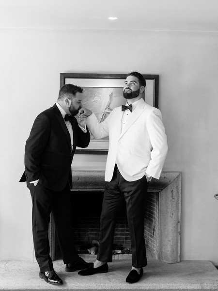 Groom standing confidently in white dinner jacket and black bow tie at Margi luxury hotel