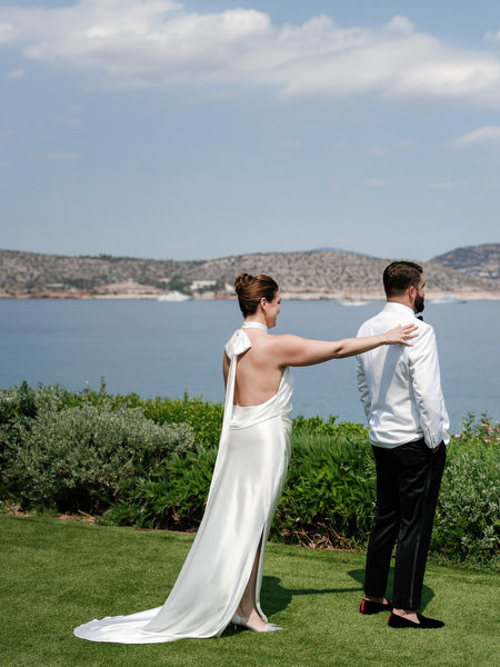 Groom standing confidently in white dinner jacket and black bow tie at Margi luxury hotel