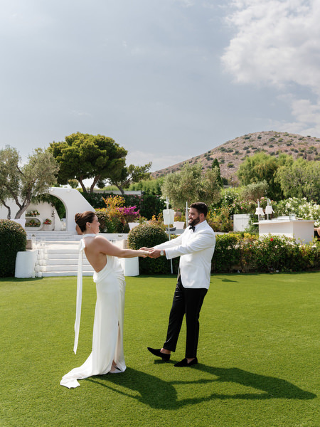 Bride holding groom’s hands during joyful first look moment at Island Resort