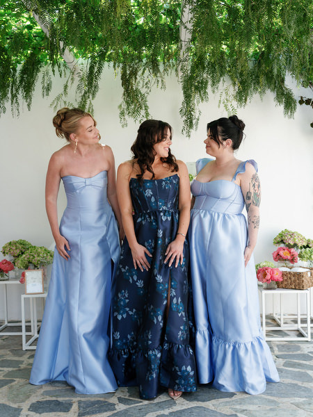 Bridesmaids in soft blue and navy dresses posing beneath hanging greenery at Island Resort