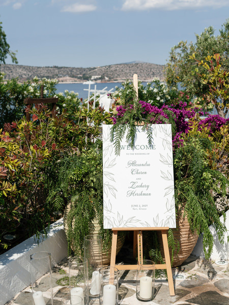 Jewish wedding welcome sign surrounded by coral and blush floral arrangements