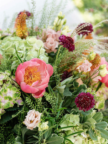 Lush wedding florals featuring peonies, hydrangeas, and seasonal blooms