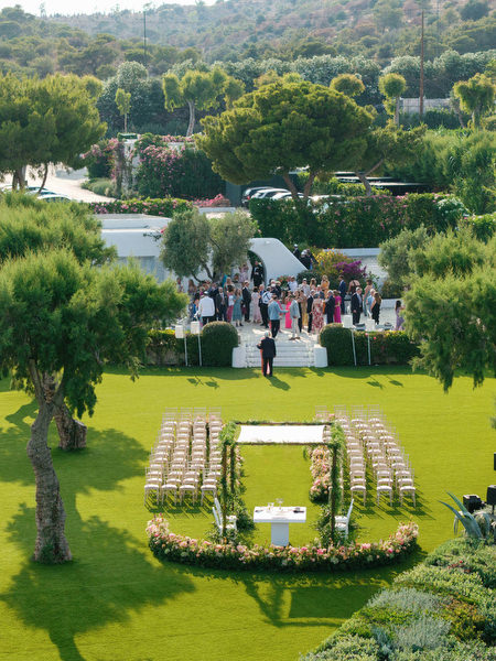 Drone view of ceremony lawn with chuppah centered above the coastline