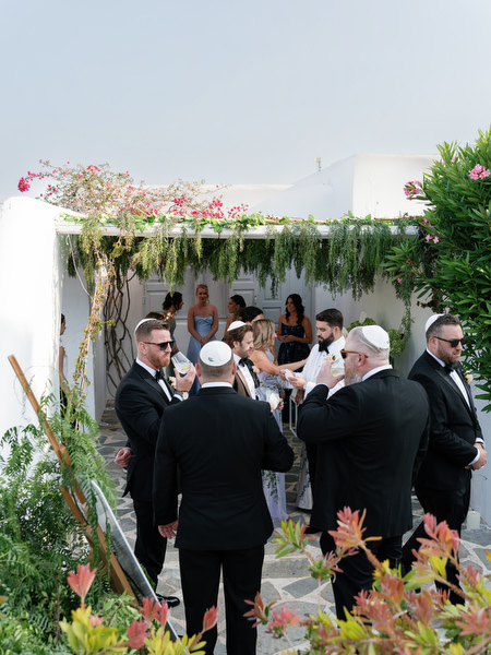 Guests gathering beneath floral chuppah at Island Resort Athens Riviera