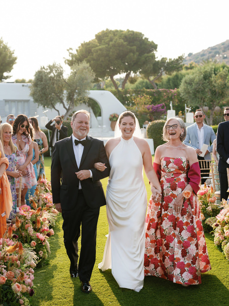 Bride escorted by her parents beneath golden hour light at Island Residence