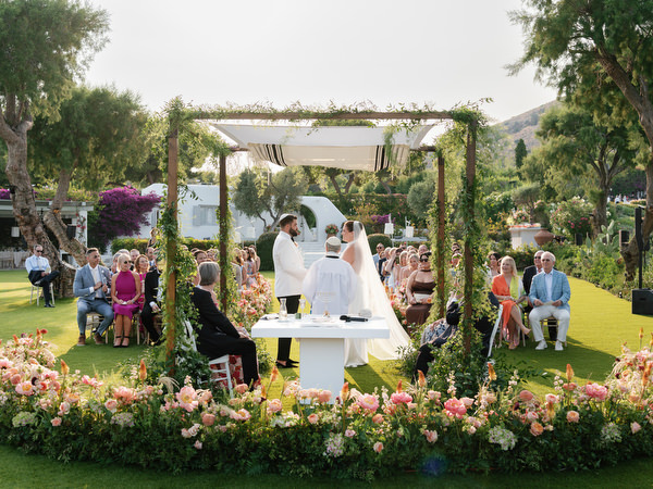 Jewish ceremony unfolding beneath greenery-covered chuppah overlooking the sea at Island Residence