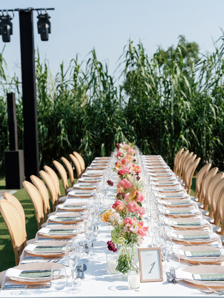 Minimal white tablescape with low coral floral arrangements and gold accents at Island Residence
