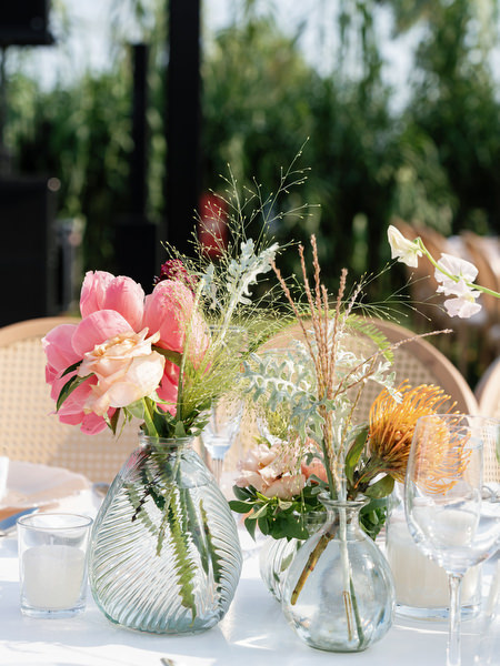 Textured coral and blush arrangement in clear glass vases at Island Residence