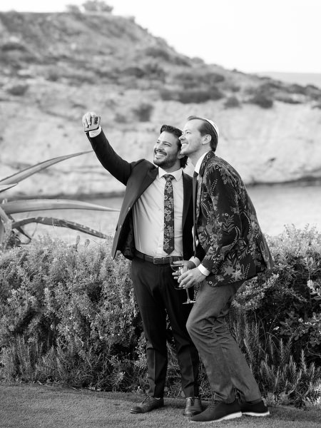 Guests taking a celebratory selfie with the Athenian Riviera cliffs behind them