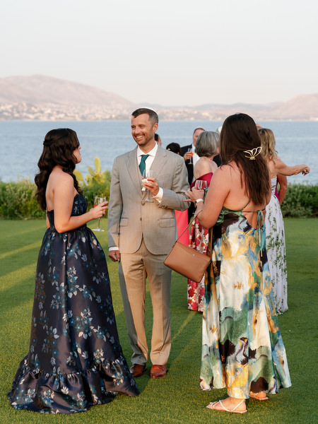 Elegant guests mingling on the lawn overlooking the Mediterranean