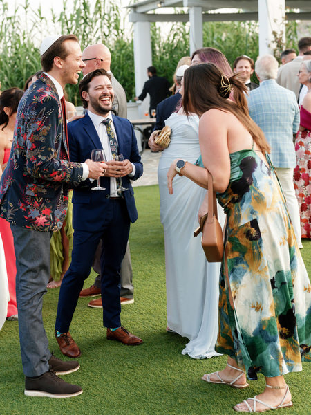 Friends laughing mid-conversation with sunset light softening the scene