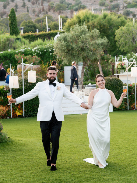 Bride and groom smiling as they walk across the lawn post-ceremony at Island Residence