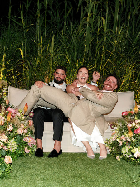 Bride laughing with family members surrounded by coral and blush florals at Island Residence