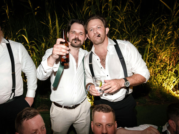Groomsmen raising drinks on the dance floor at Island Residence