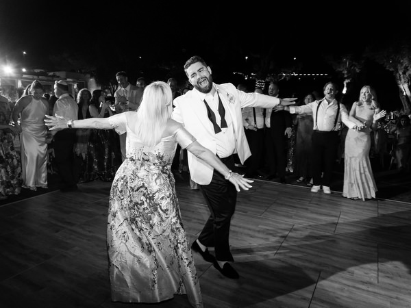 Groom twirling under night lights as the dance floor fills at Island Residence