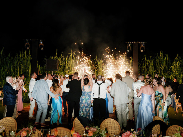 Spark fountains exploding as guests surround the couple at Island Residence