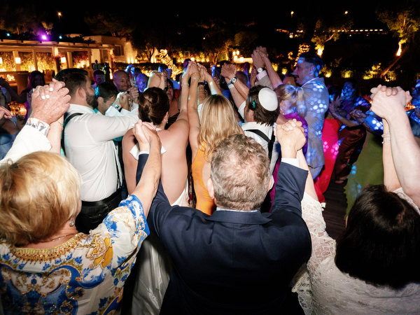 Guests forming a lively circle, hands raised, dancing with unstoppable energy at Island Residence