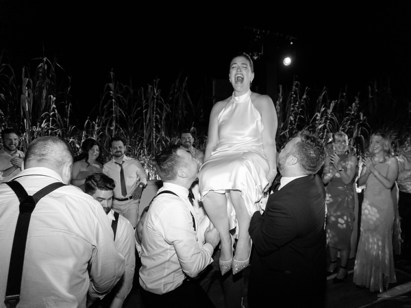 Bride raised high above cheering guests during the traditional Jewish dance at Island Residence