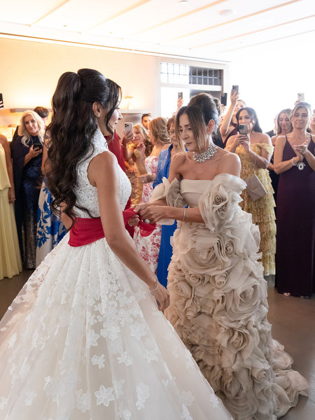 Family tying traditional red wedding sash around the bride during Cypriot wedding customs in Athens
