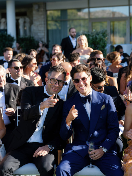 Guests seated at an outdoor wedding ceremony overlooking the Aegean Sea