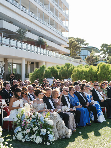Guests seated at a seaside wedding ceremony overlooking the Aegean Sea