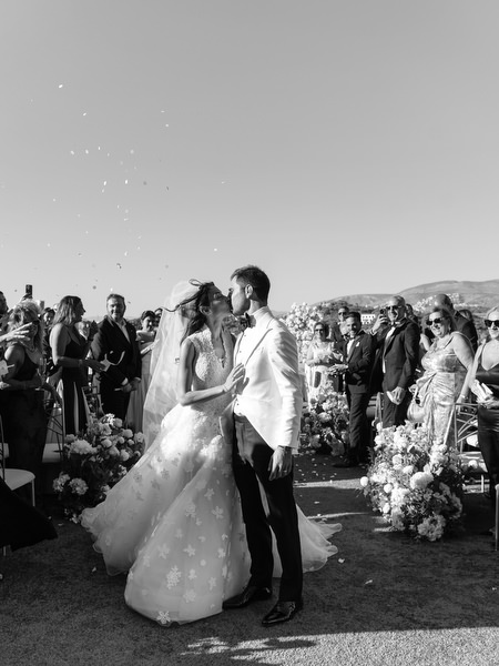 Newlyweds walking down the aisle after their seaside wedding ceremony in Athens