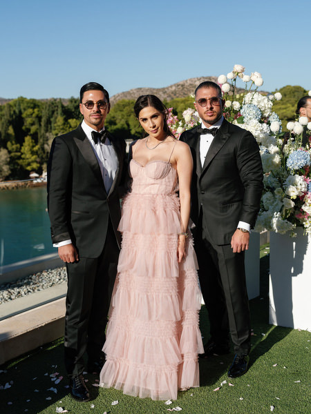 Wedding guests posing with Athens Riviera coastline backdrop