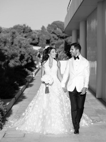 Bride and groom walking hand in hand after their Four Seasons Athens ceremony