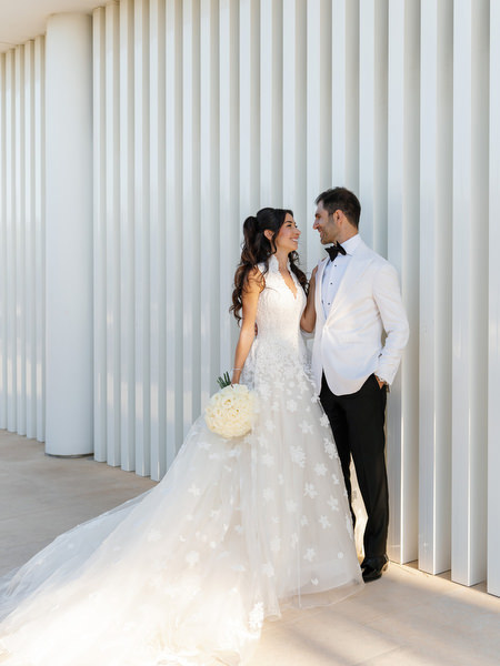 Bride and groom posing at Four Seasons Astir Palace during their luxury Athens Riviera wedding