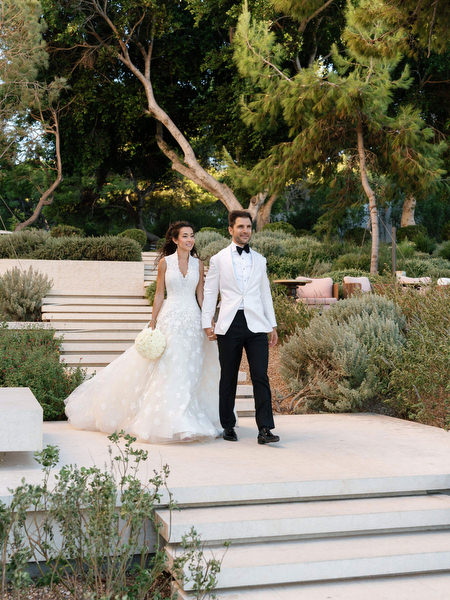 Newlyweds walking through landscaped gardens at Four Seasons Astir Palace