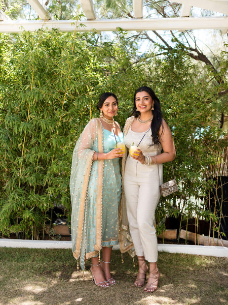 Guest in colorful lehenga posing with friends during Mehndi event