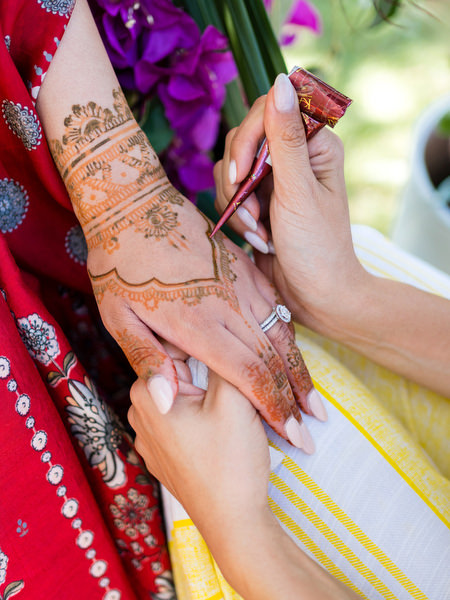 Close-up of Mehndi being applied on bride's hands