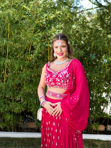 Guest posing in red lehenga during Mehndi celebration