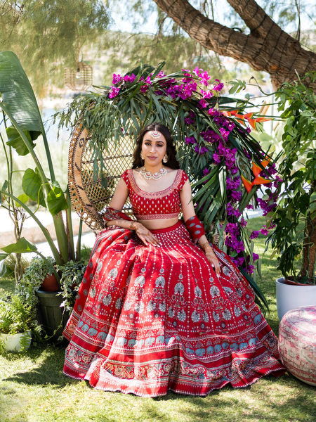 Bride portrait with floral backdrop during Indian wedding event