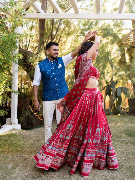 Bride twirling in red lehenga during Mehndi celebration