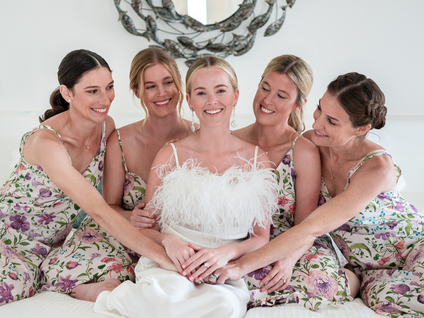 Bridesmaids in floral dresses with bride at Paros destination wedding venue.