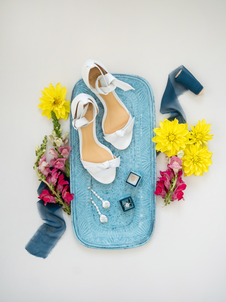 Bridal shoes and wedding details styled with yellow and pink flowers at Paros wedding.