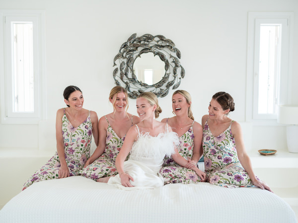 Bride sitting on white bed in modern Cycladic villa at Petra Farm Paros.