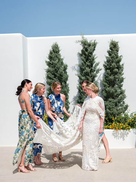 Bride in long-sleeve lace wedding gown with bridesmaids at Petra Farm Paros.