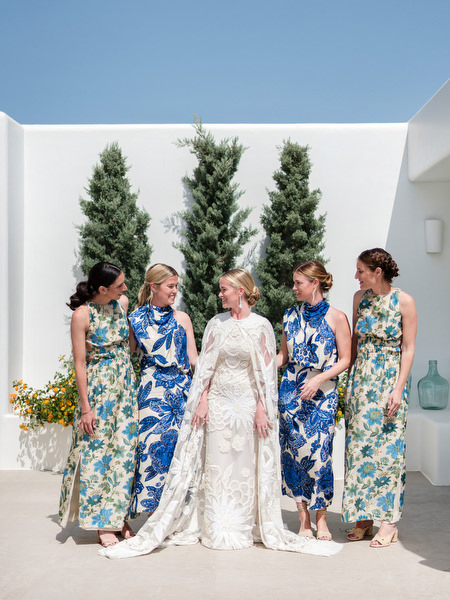 Bridesmaids in blue patterned dresses with bride at Paros Greek island wedding.